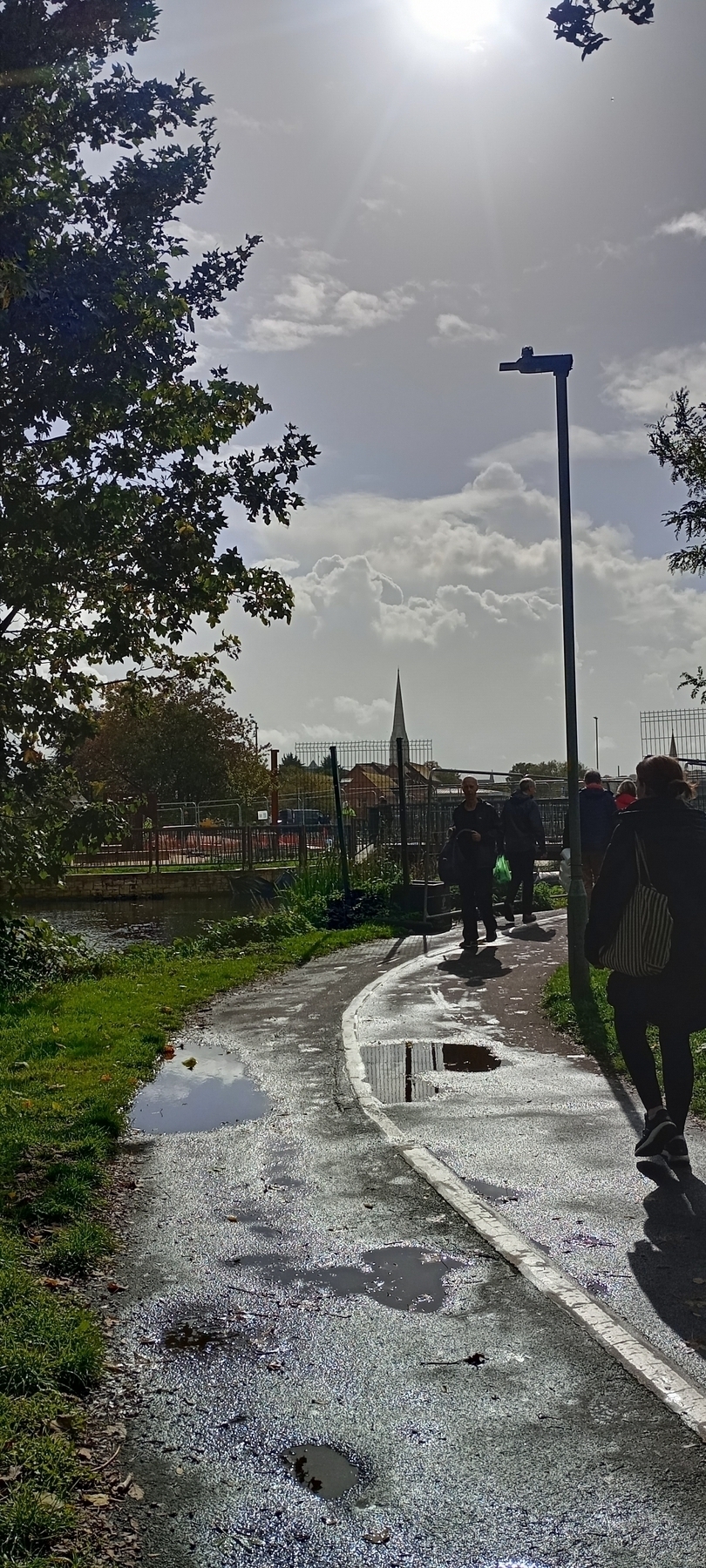 riverside path with Salisbury  cathedral in the distances, and puddles