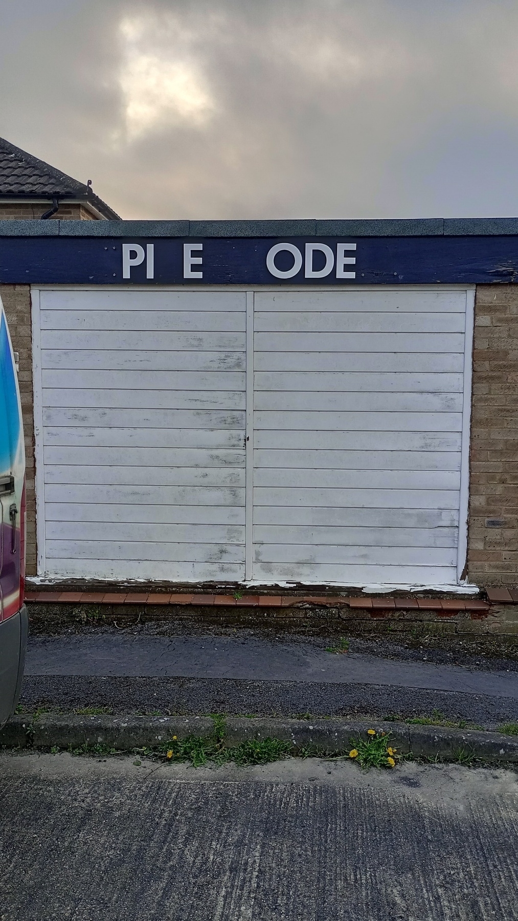 shutter shop front featuring the letters PI E ODE